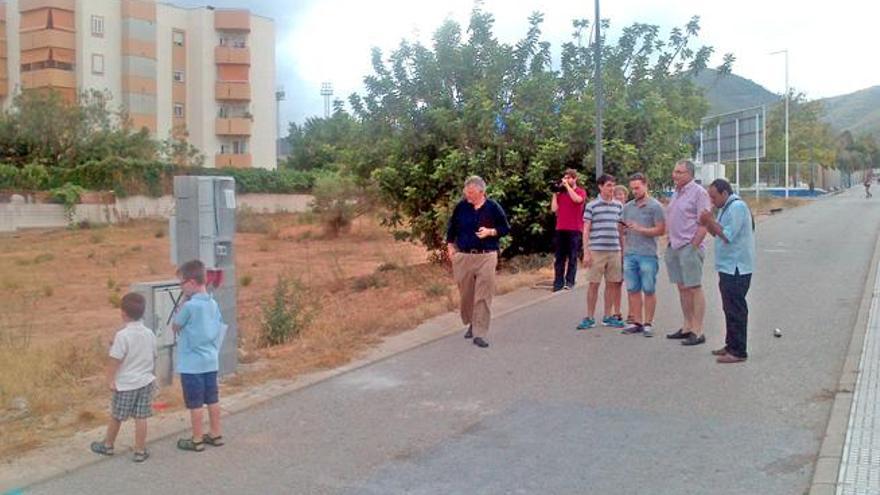 Algunos vecinos en la vía peatonal junto a la parcela y el contador.