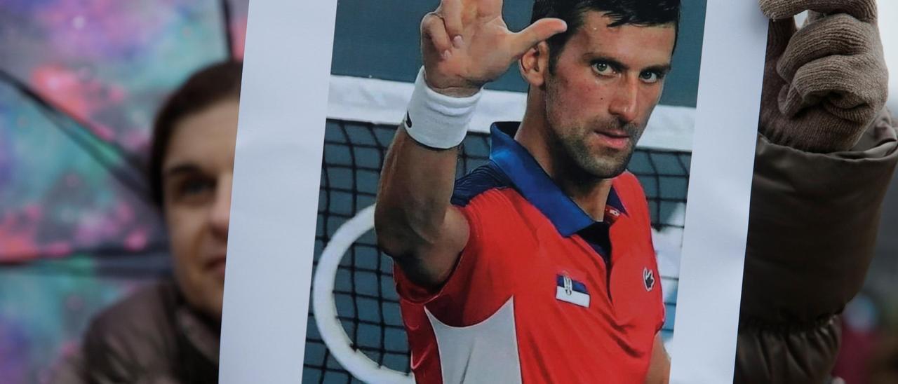Una seguidora de Novak Djokovic muestra una imagen del tenista serbio.