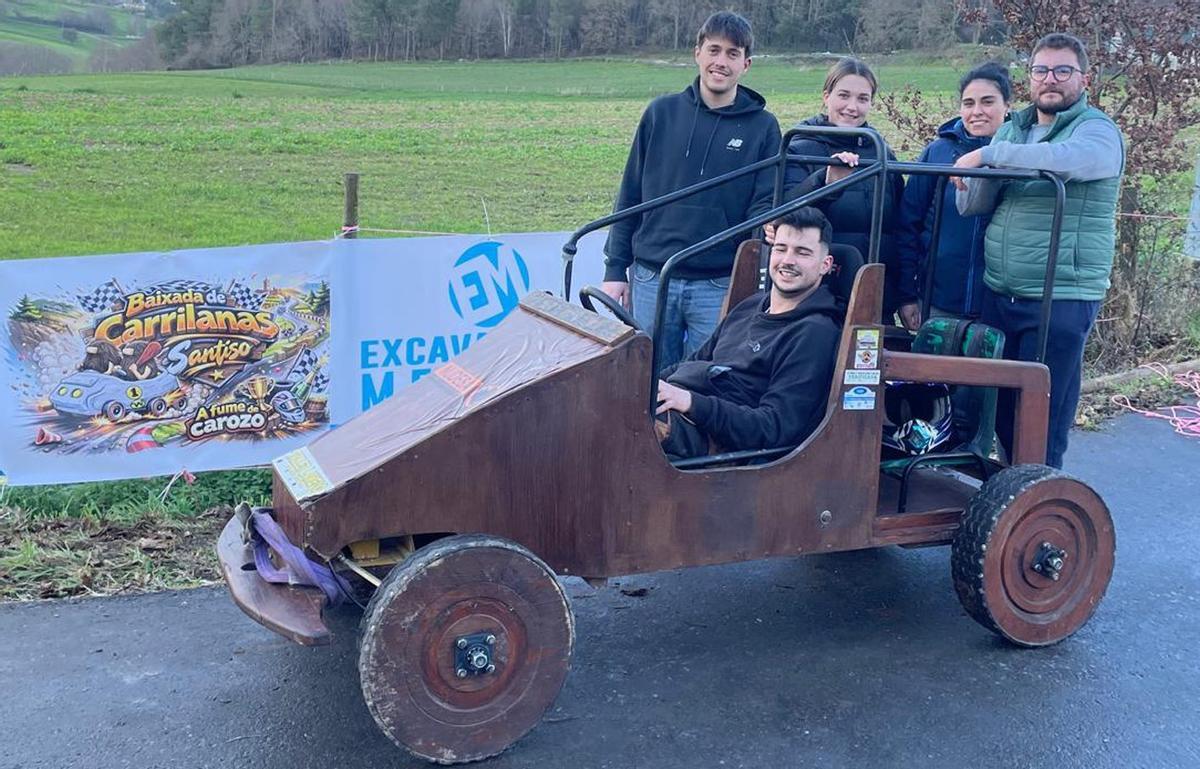 Membros da organización posan nunha carrilana co logotipo da escudería de fondo.