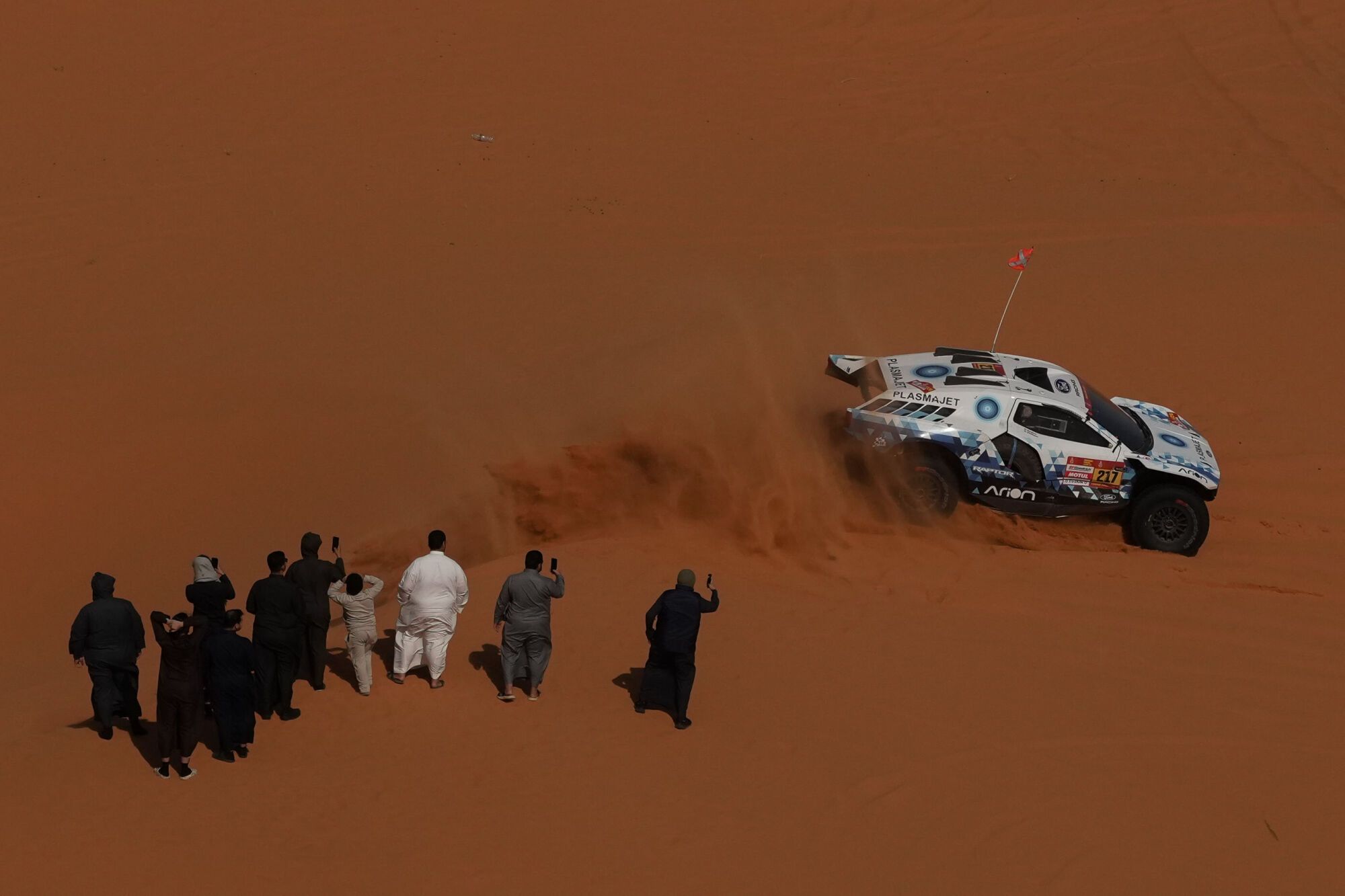 Spectators watch driver Denis Krotov and co-driver Konstantin Zhiltsov competing during the sixth stage of the Dakar Rally between Hail and Riyadh, Saudi Arabia, Friday, Jan. 9, 2026. (AP Photo/Thibault Camus). EDITORIAL USE ONLY/ONLY ITALY AND SPAIN