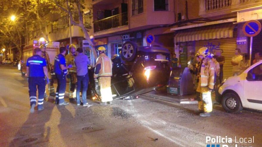 Varios agentes, junto al coche volcado en la calle Eusebi Estada