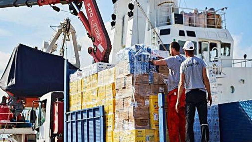 Dos operaris carreguen aliments a l&#039;Open Arms, al Port de Barcelona.