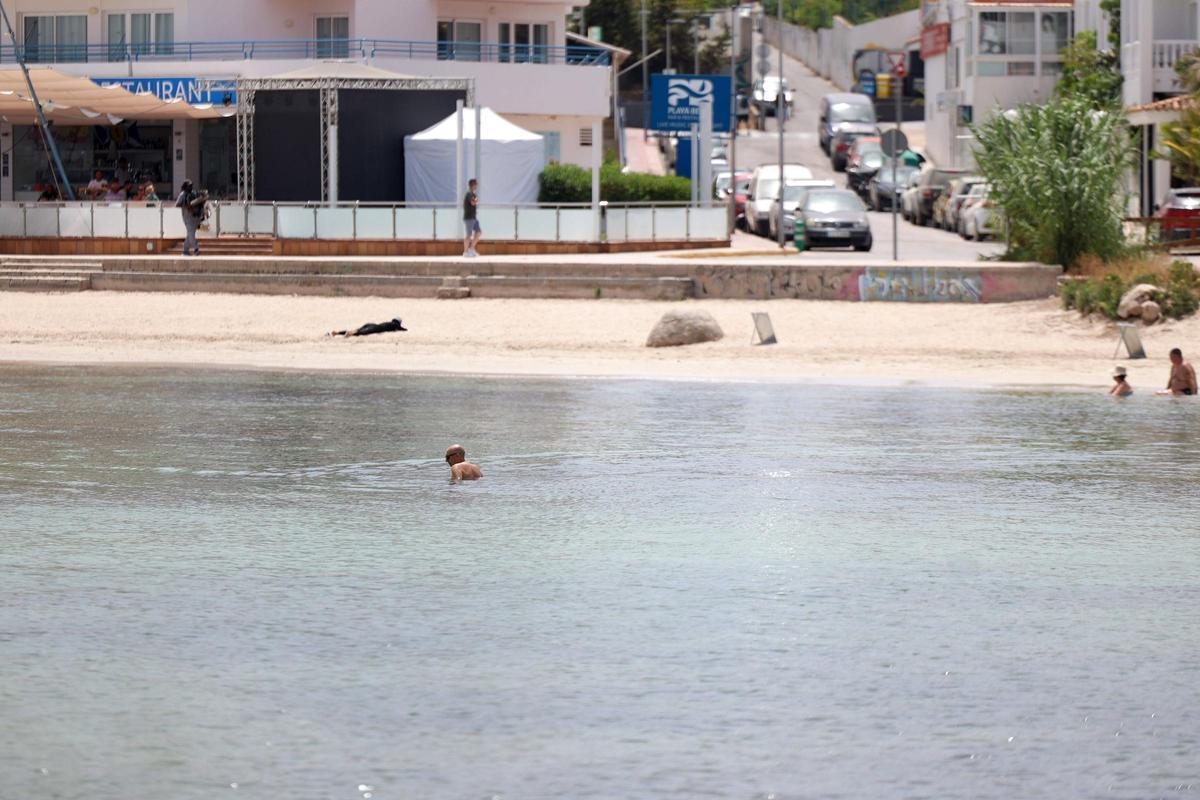 Bañistas en la playa de es Pinet, cerrada al baño por vertidos fecales