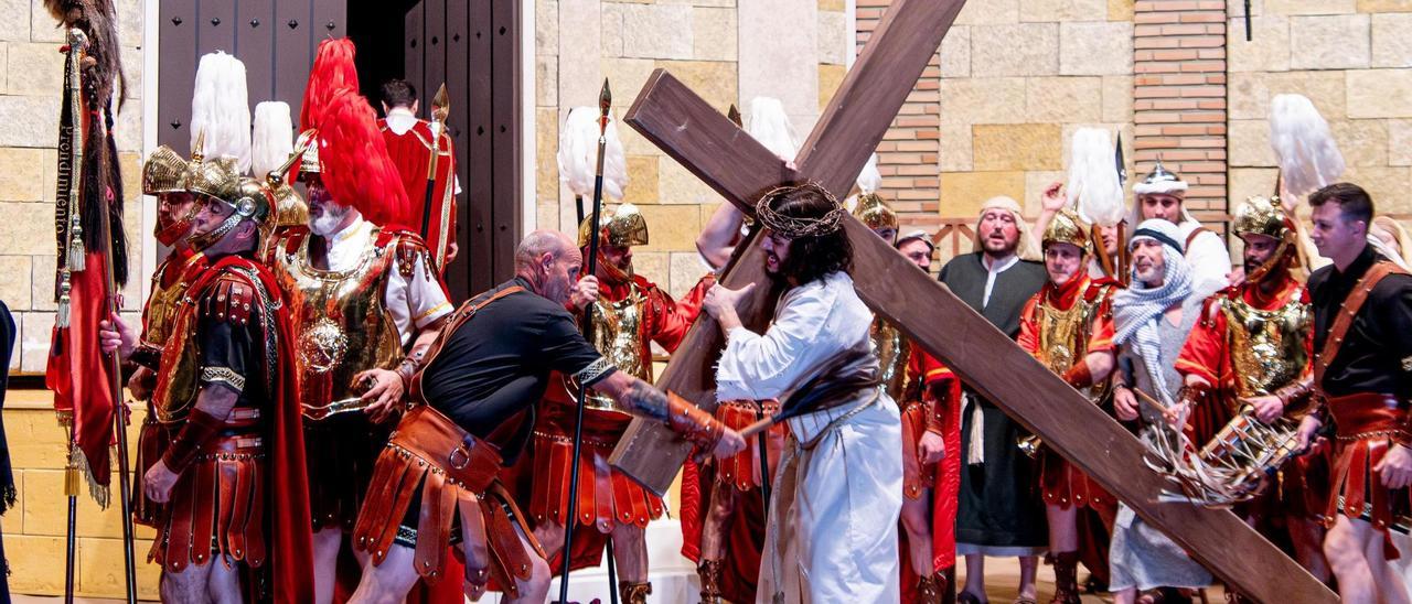 Jesús es azotado mientras carga con la cruz, camino del monte Calvario.