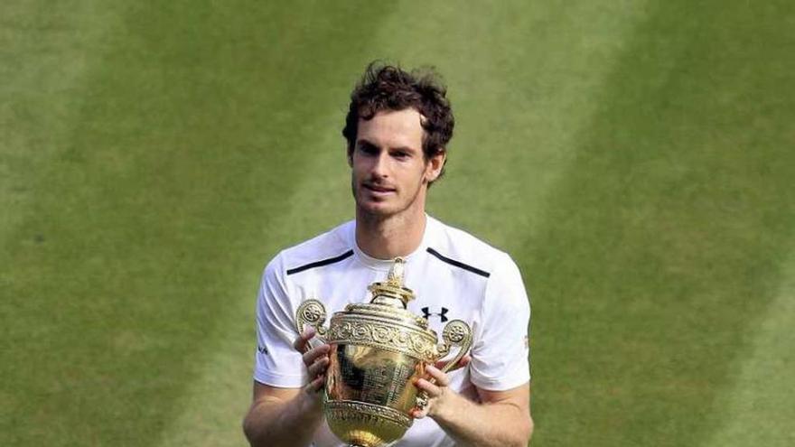 Murray sostiene el trofeo en la hierba de Wimbledon. // John Walton