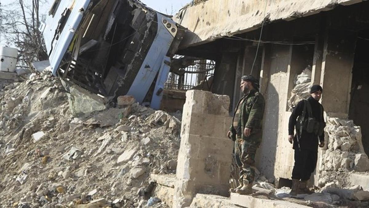 Rebeldes sirios junto a las ruinas del palacio de justicia de la ciudad vieja de Alepo, en Siria, el 28 de enero.