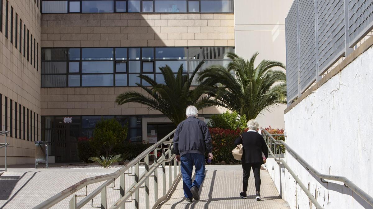 Dos usuarios frente a uno de los accesos del Hospital de la Ribera, en una imagen de archivo.