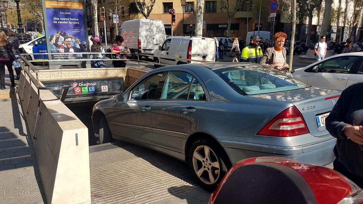 El conductor de un coche confunde la entrada del metro con un párking en el paseo de Gràcia.