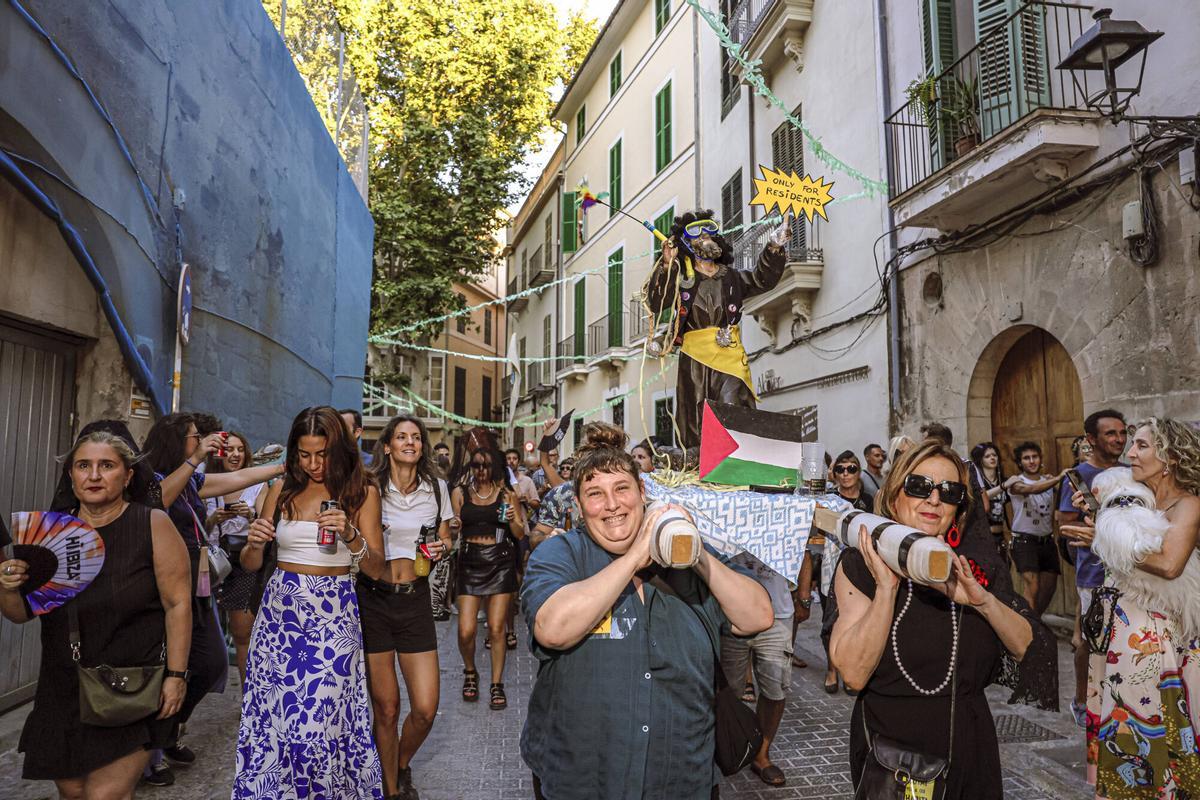 Vecinos de la Calatrava y Canamunt, muchos vestidos de verde y con ramas de árboles, se unen durante sus cercavilas para homenajear a los bellasombras talados en la plaza Llorenç Villalonga.