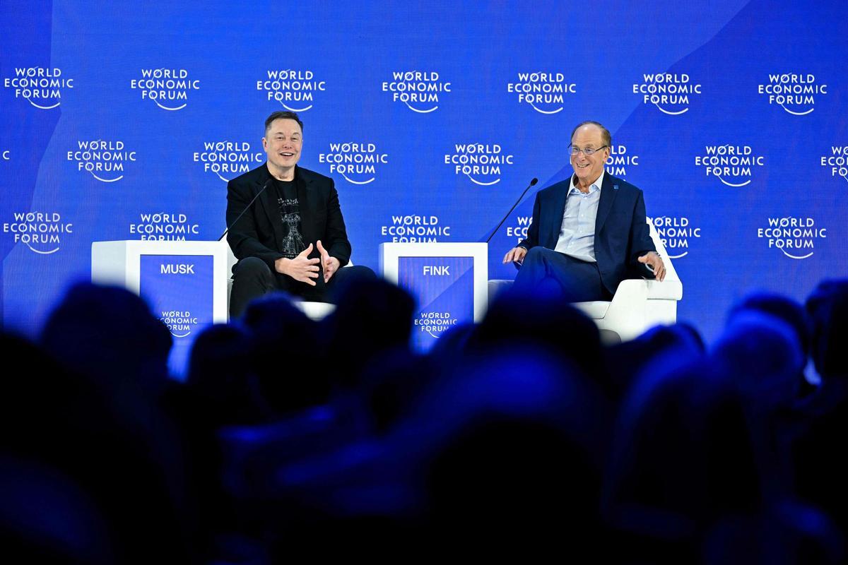 El magnate tecnológico Elon Musk, dueño de SpaceX, Tesla y X habla con el presidente del fondo BlackRock, Larry Fink, en Davos 2026.