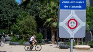Un ciclista cruza la plaza de Girona con Consell de Cent.