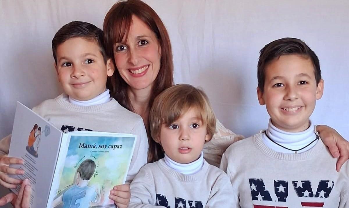 Carmen Galán, con sus tres hijos y el cuento 'Mamá, soy capaz'.