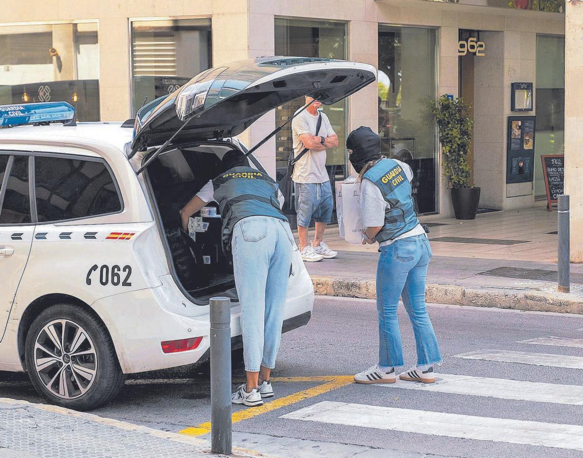 Agentes de la Guardia Civil trasladan el material intervenido en el registro del despacho de abogados de Palma.