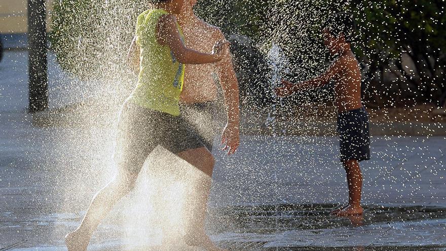 Tres niños jugando con agua en el Cuartel de Artillería, hace unos días.