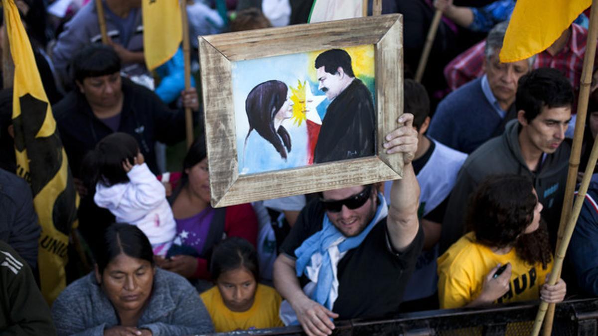 Participantes en el multitudinario acto en Buenos Aires muestran un cuadro en el que aparecen Nicolás Maduro y Cristina Fernández.