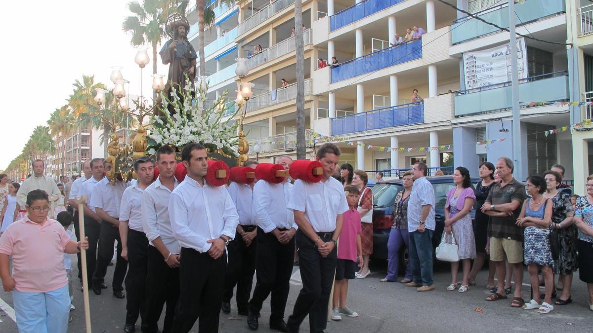 Los vecinos y vecinas contemplan la imagen de Sant Roc durante la procesión que se celebra el día grande de las fiestas.