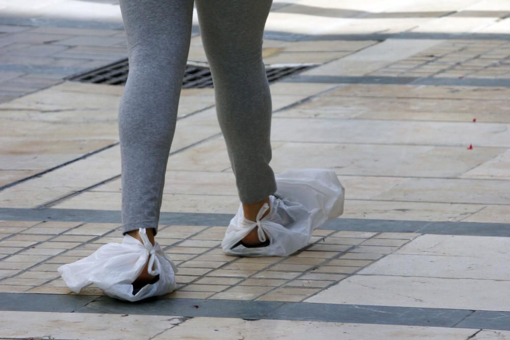 Mascarillas y guantes ya se han convertido en un complemento más de los malagueños, que siguen aprovechando las franjas horarias permitidas para dar sus paseos mientras los pequeños establecimientos se preparan para una reapertura cuando el progreso en la desescalada lo permita