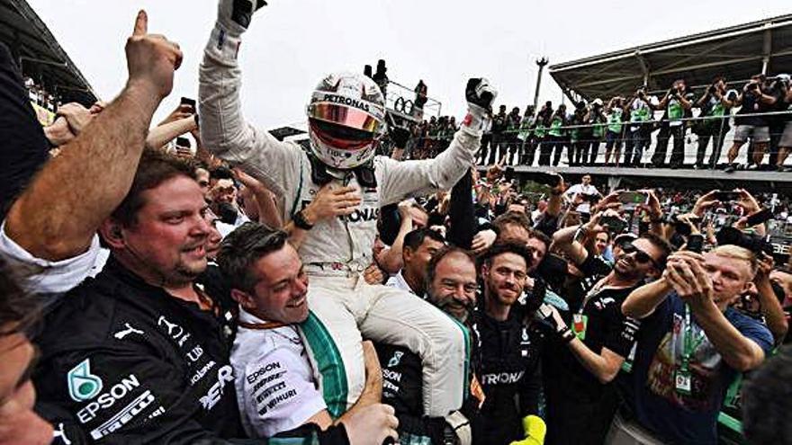 El equipo Mercedes festeja el título mundial por escuderías llevando en volandas a Hamilton.