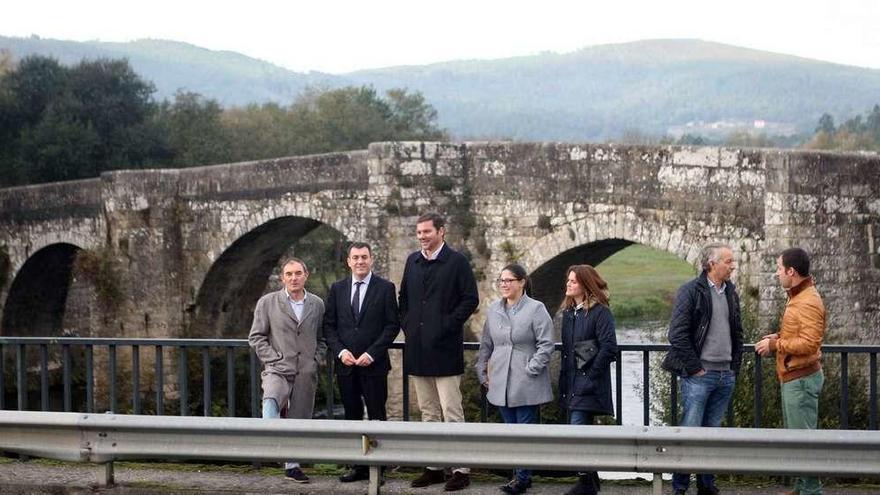 El conselleiro de Cultura, entre los alcaldes de Teo y A Estrada, con el puente como telón de fondo. // Bernabé/Ana Agra