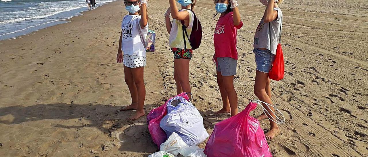 Noelia i les tres amigues amb les bosses utilitzades per arreplegar les deixalles.