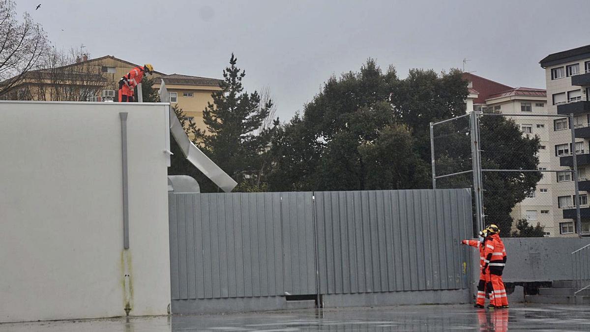 Los bomberos de Pontevedra retiran parte de la cubierta del complejo deportivo de Campolongo. |   // R.V. 