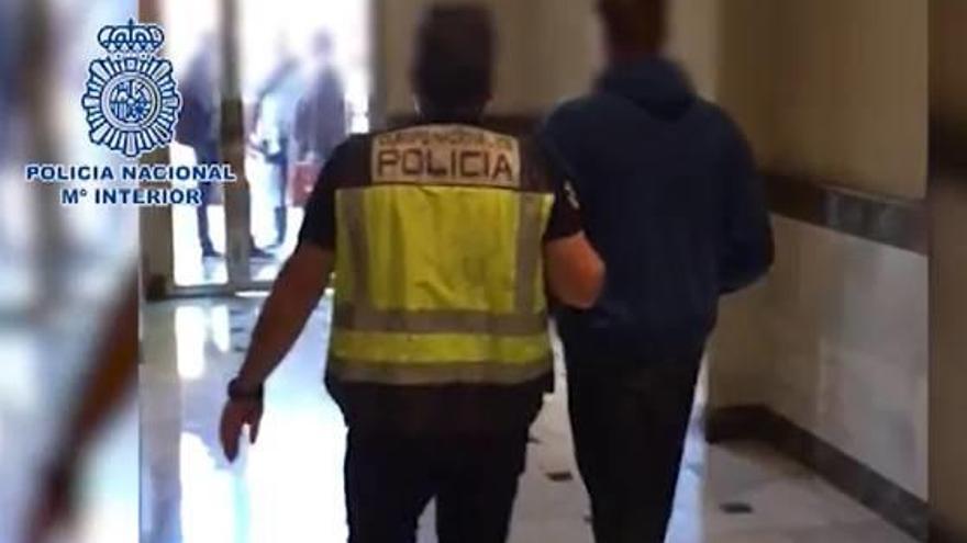 Un policía traslada a uno de los detenidos en la operación.