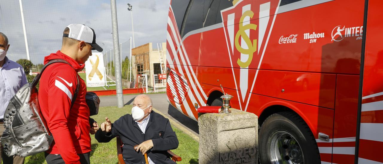 El páter Fueyo charla con Djuka ante el nuevo autobús del Sporting