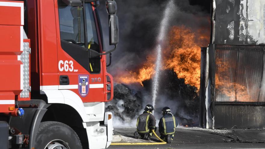 Dos bomberos tratan de sofocar las llamas en uno de los incendios ocurridos en abril.