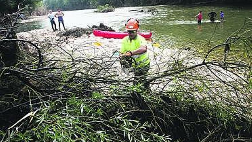 Dos excursionistas pasan sin dificultades por debajo del puente de Toraño, cuyas barandillas quedaron dañadas durante la «riadona» del pasado 16 de junio.