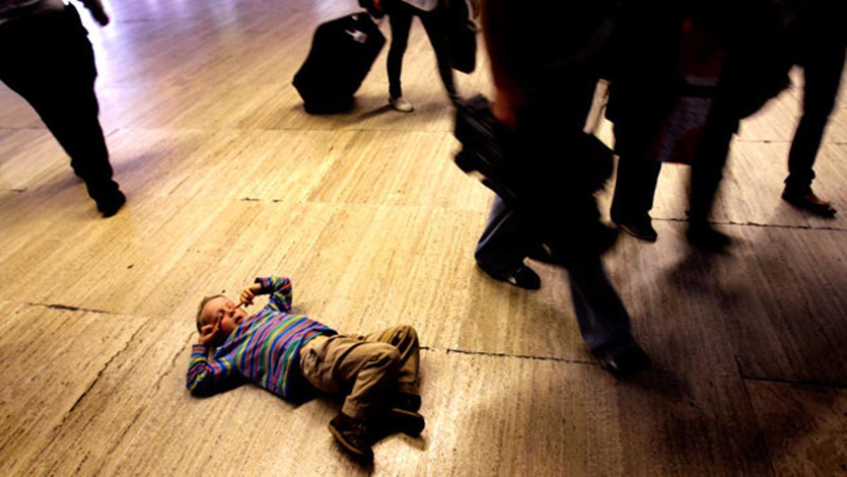 Un nen descansa a terra després de la cancel·lació de vols a l¿aeroport de Sevilla pels efectes del núvol volcànic.