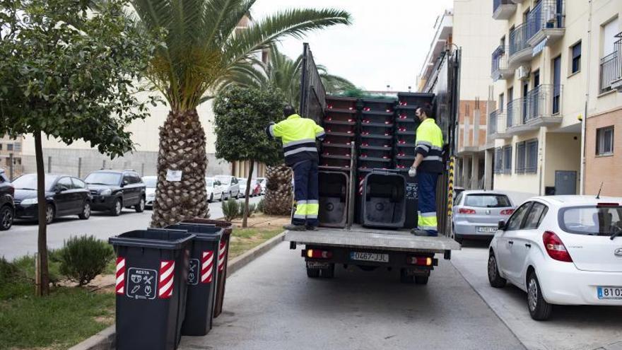 Trabajadores de la adjudicataria del servicio, ayer en pleno reparto de los contenedores. | PERALES IBORRA