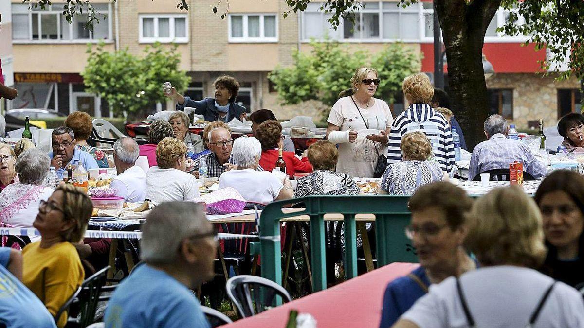 Participantes en la comida en La Libertad y, a la derecha, miembros de &quot;Güeyar y Trapiñar&quot; cocinando en el parque, ambas fotos de la edición del año pasado