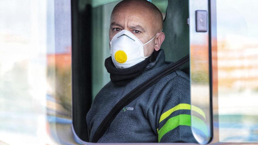 Un conductor de Titsa cumple con su jornada laboral protegido con una mascarilla.