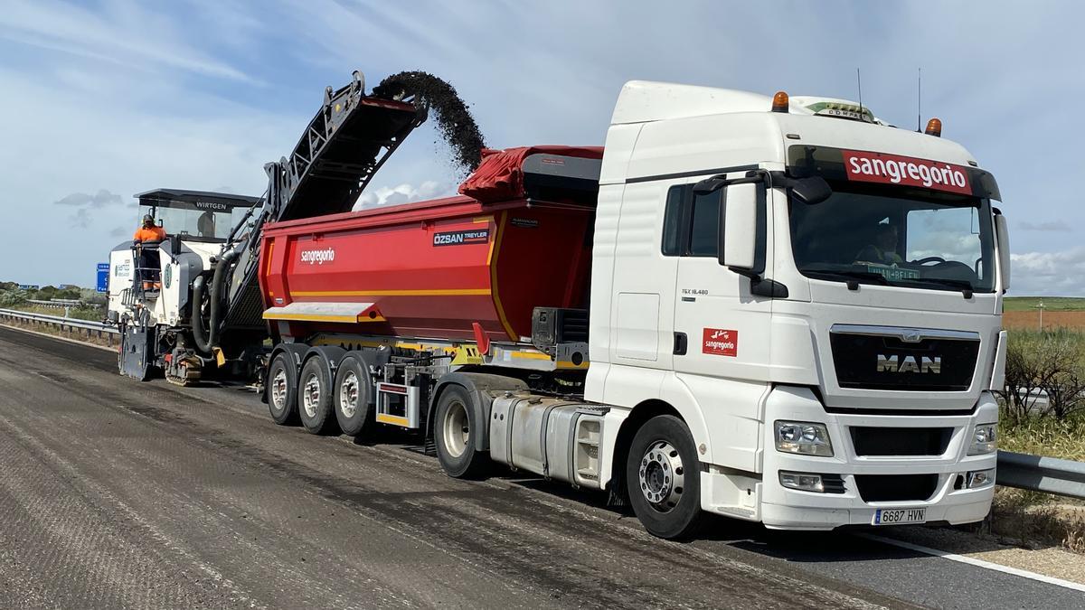 Un camión de Contratas y Obras San Gregorio asfalta una carretera.