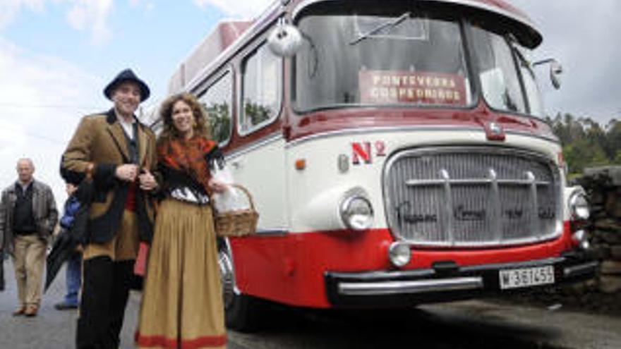 Una pareja vestida con trajes tradicionales ante un autobús de época.  // Noé Parga