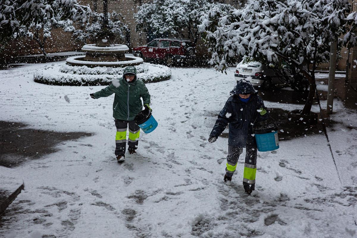 Dos operarias del ayuntamiento de Solsona esparcen sal por las calles.