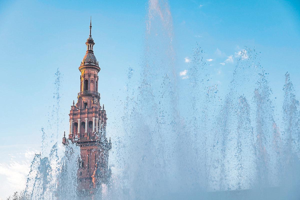 Water from a fountain bubbling in front of one of the towers of the Plaza de España in Seville (panoramic view)