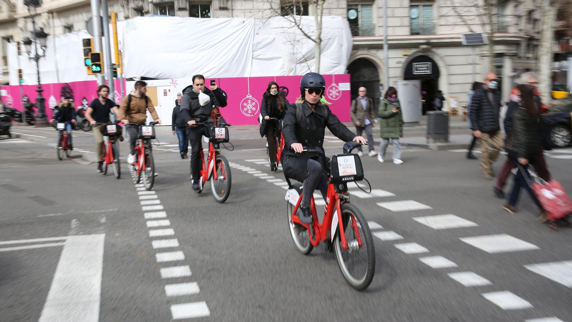 Barcelona 28/02/2022 Barcelona Informe de la Bicicleta Club de Catalunya sobre movilidad. Reportaje de bicis, bicing, patinetes, chicas con montainebike,...Glovo en la Pça./ Francesc Macià con Diagonal . FOTO DE RICARD CUGAT