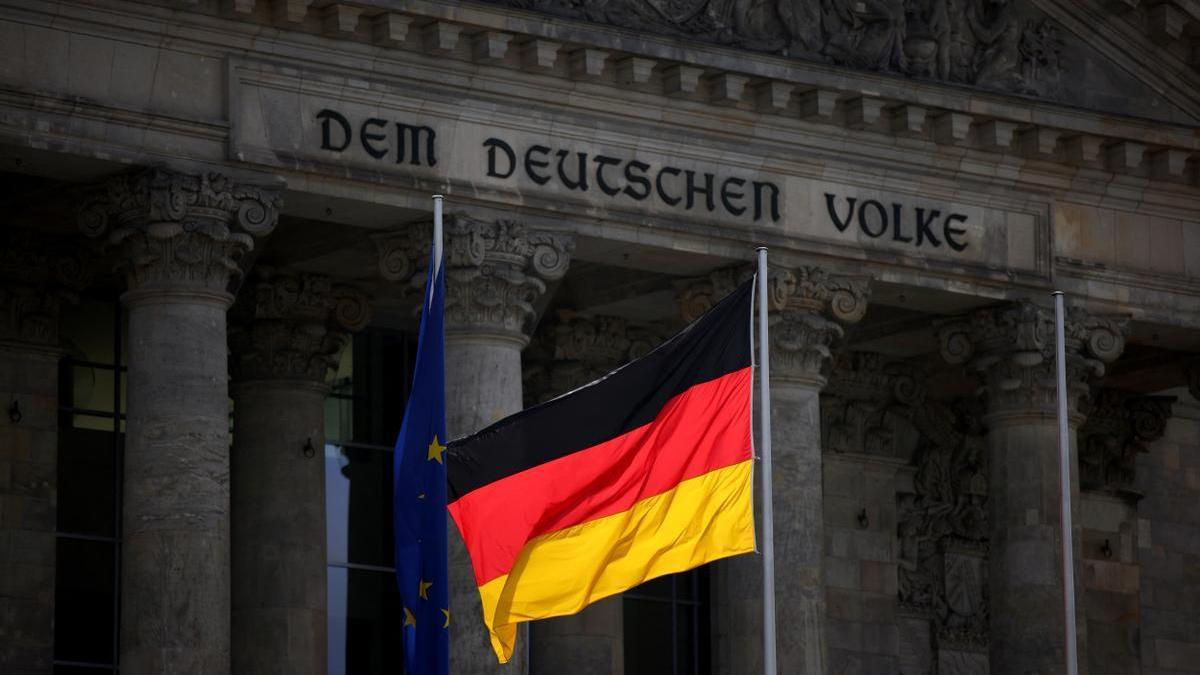 La bandera alemana ondea frente al edificio del Reichstag.