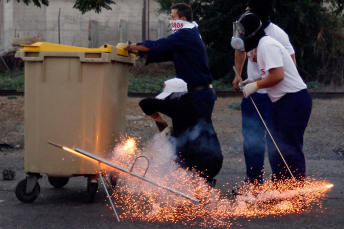 Uns treballadors disparen un coet durant un enfrontament amb la policia a les instal·lacions de les drassanes de Sevilla. Protesten pel tancament imminent de la drassana.