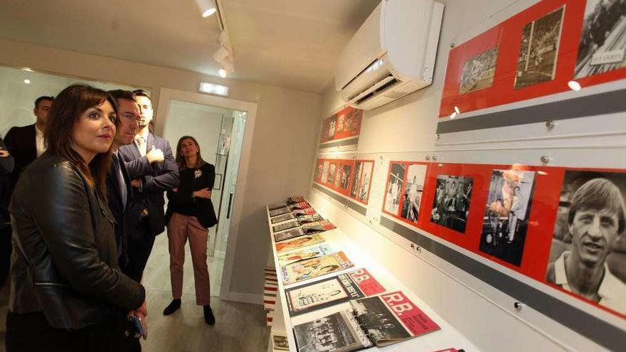 Visitantes viendo algunas de las fotografías de Cruyff y material deportivo recopilado en la empresa i-Lanza, en Roces.