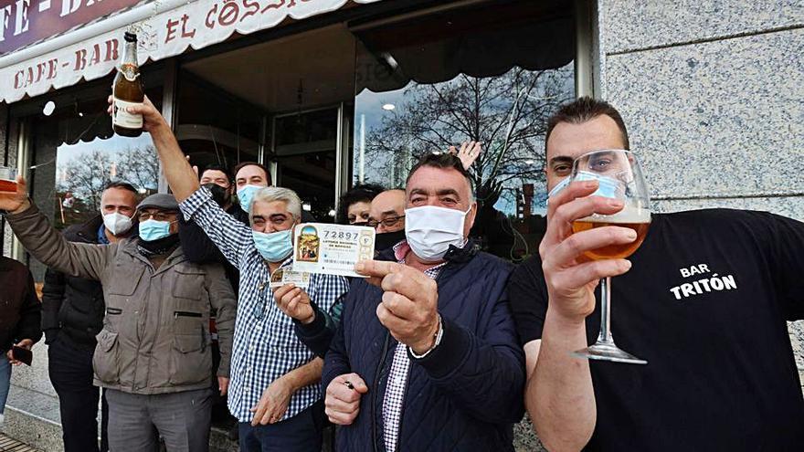 Esteban y clientes de su bar de Salamanca, celebrando el premio. |   // EFE