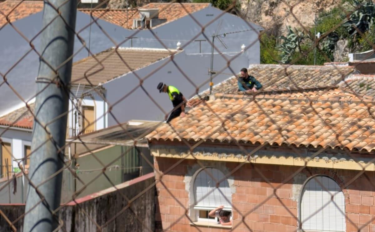 Agentes de la Policía Local de Luque y la Guardia Civil intentan acceder a la vivienda desde el tejado, en una imagen tomada por un vecino de la localidad.