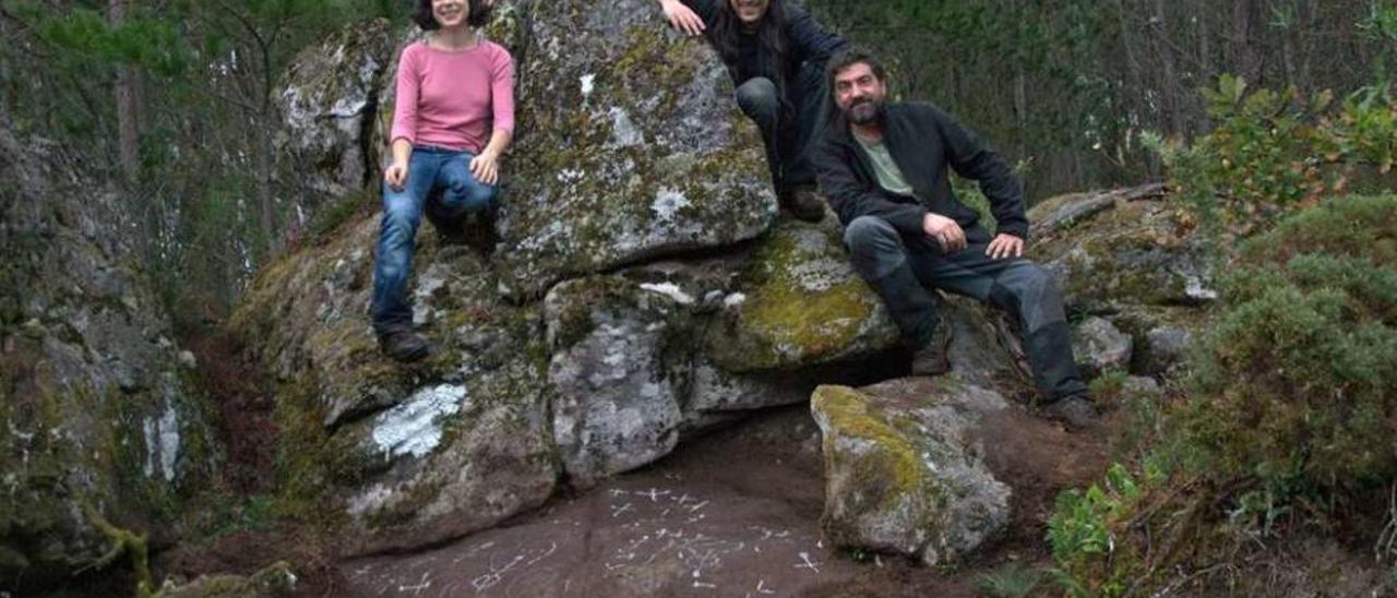 Membros de Capitán Gosende a carón do petróglifo da Laxa da Romaxe. // Xoán Soto