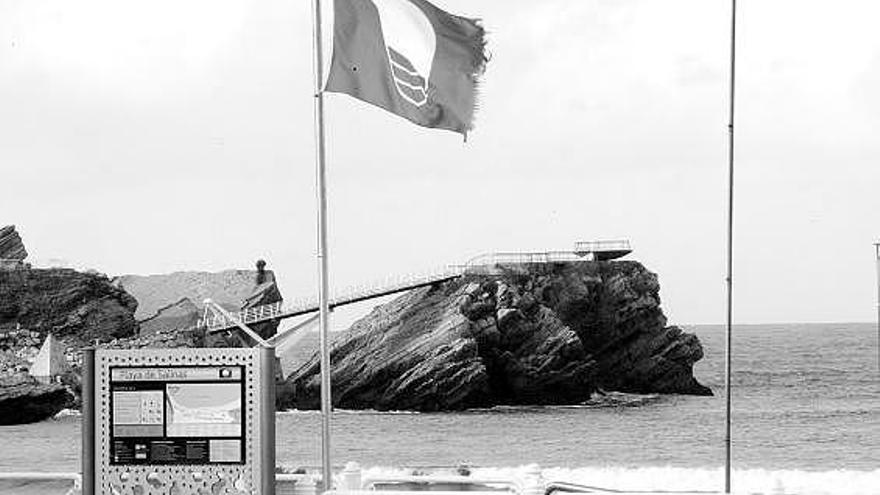 La bandera azul que ondeó el verano pasado en la playa de Salinas, con La Peñona al fondo.