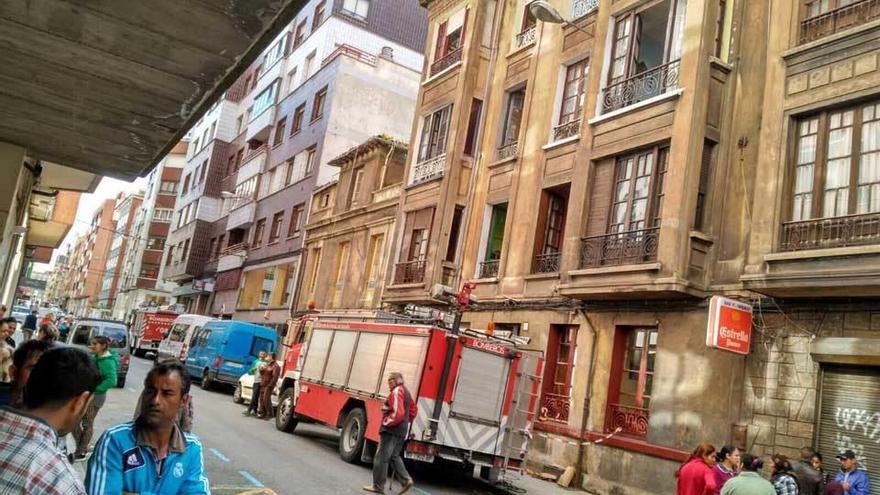 Varios de los inquilinos del edificio de la calle Caveda esperan mientras los bomberos comprueban el estado del inmueble.