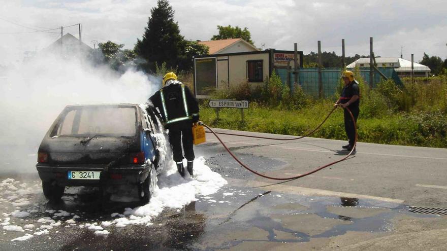 Efectivos de Emerxencias de Sada durante las labores de extinción de un incendio en un coche. |   // L.O.