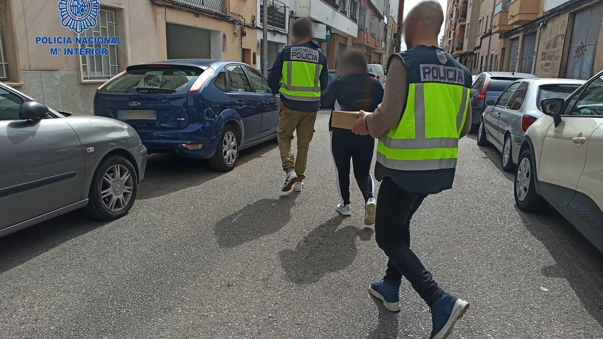 Beamte der Polizei mit einem der mutmaßlichen Täter