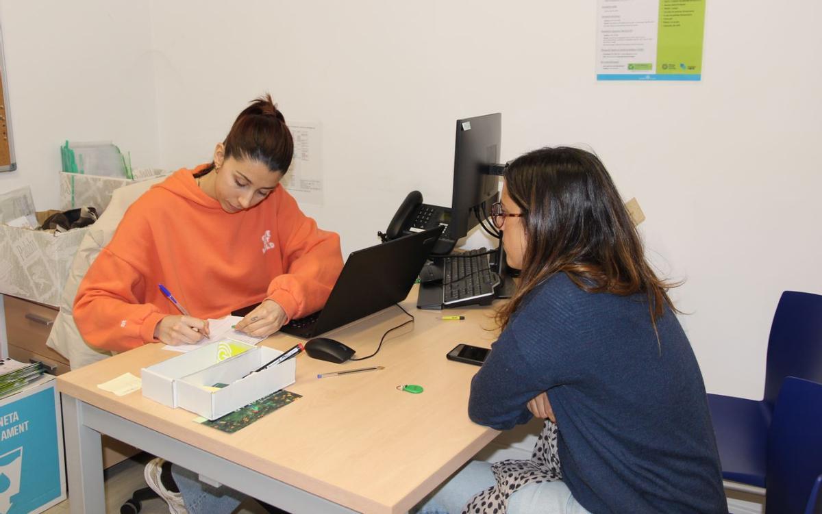 Una veïna recull el clauer de residus en una oficina de suport de Girona.