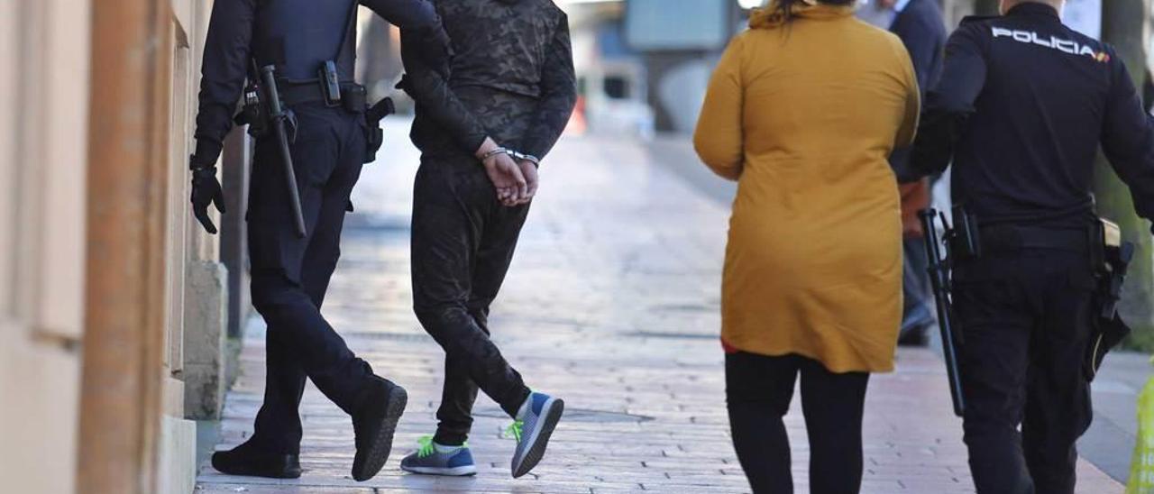 Los dos detenidos, en el momento de entrar en la Jefatura de Policía, en Oviedo.